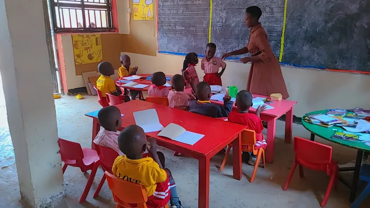 A teacher guiding children during a nursery lesson